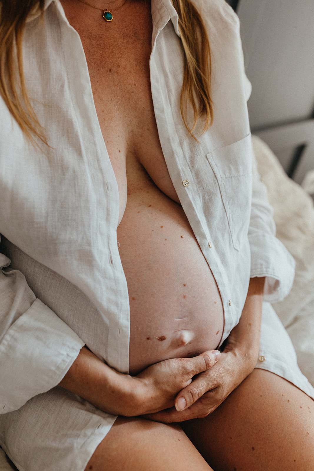 ventre de femme enceinte avec nombril qui sort et chemise blanche