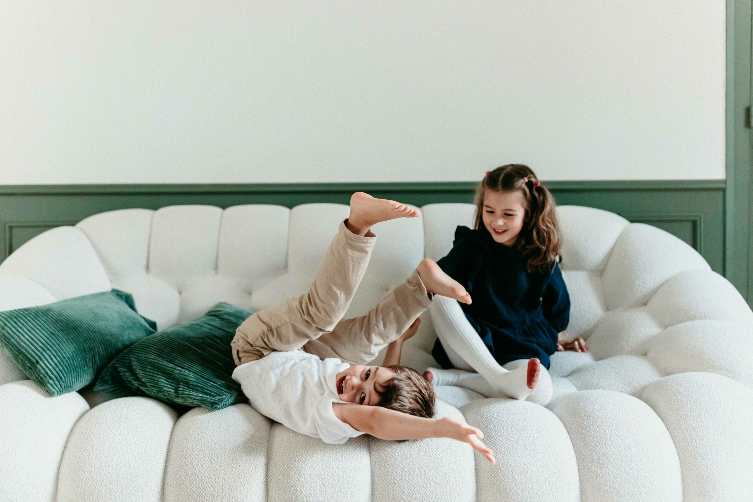 enfants qui jouent sur un canapé blanc