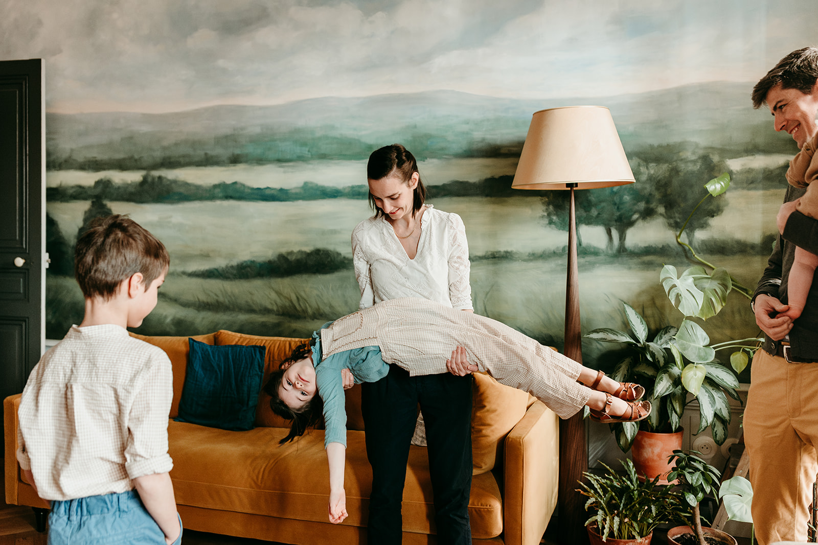 maman porte sa fille immense, le papa et le frère regardent