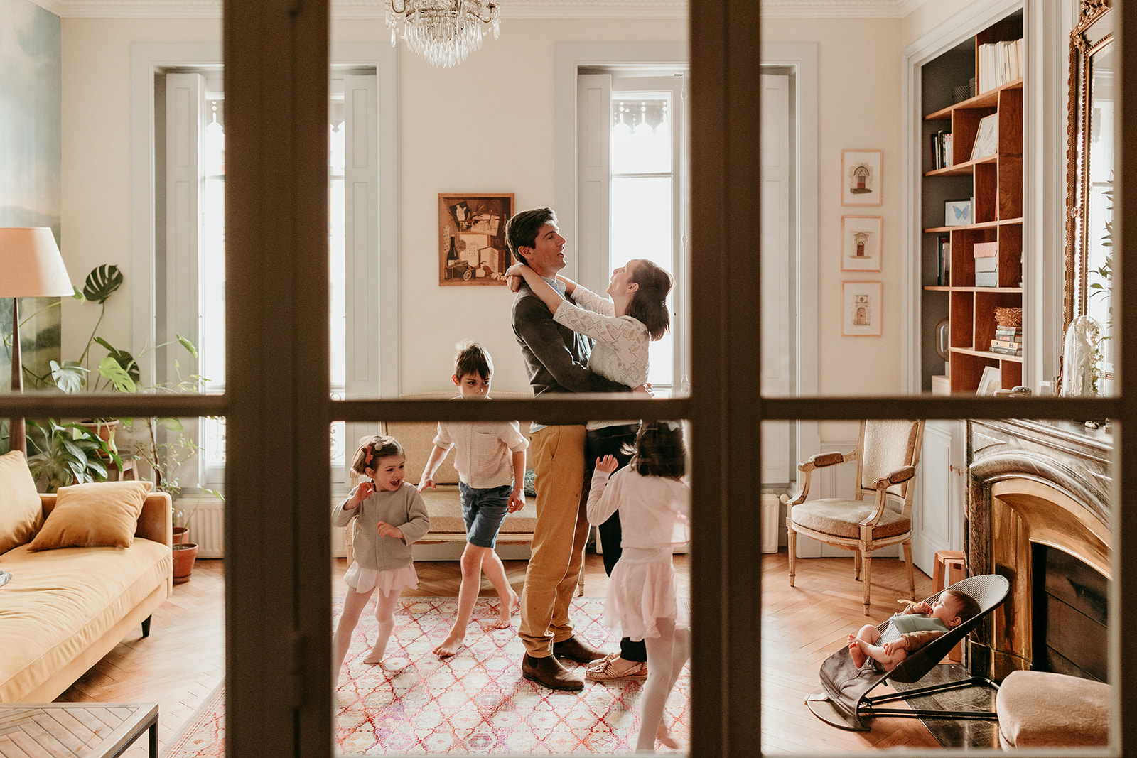 parents qui s'embrassent dans leur salon pendant que les enfants tournent autour